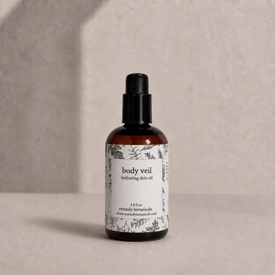 Body Veil  in an amber plastic pump bottle on a soft beige background.