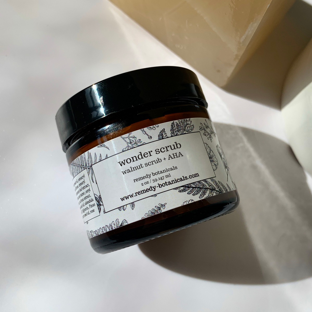 A close up bottle of wonder scrub laying on an elegant white table.
