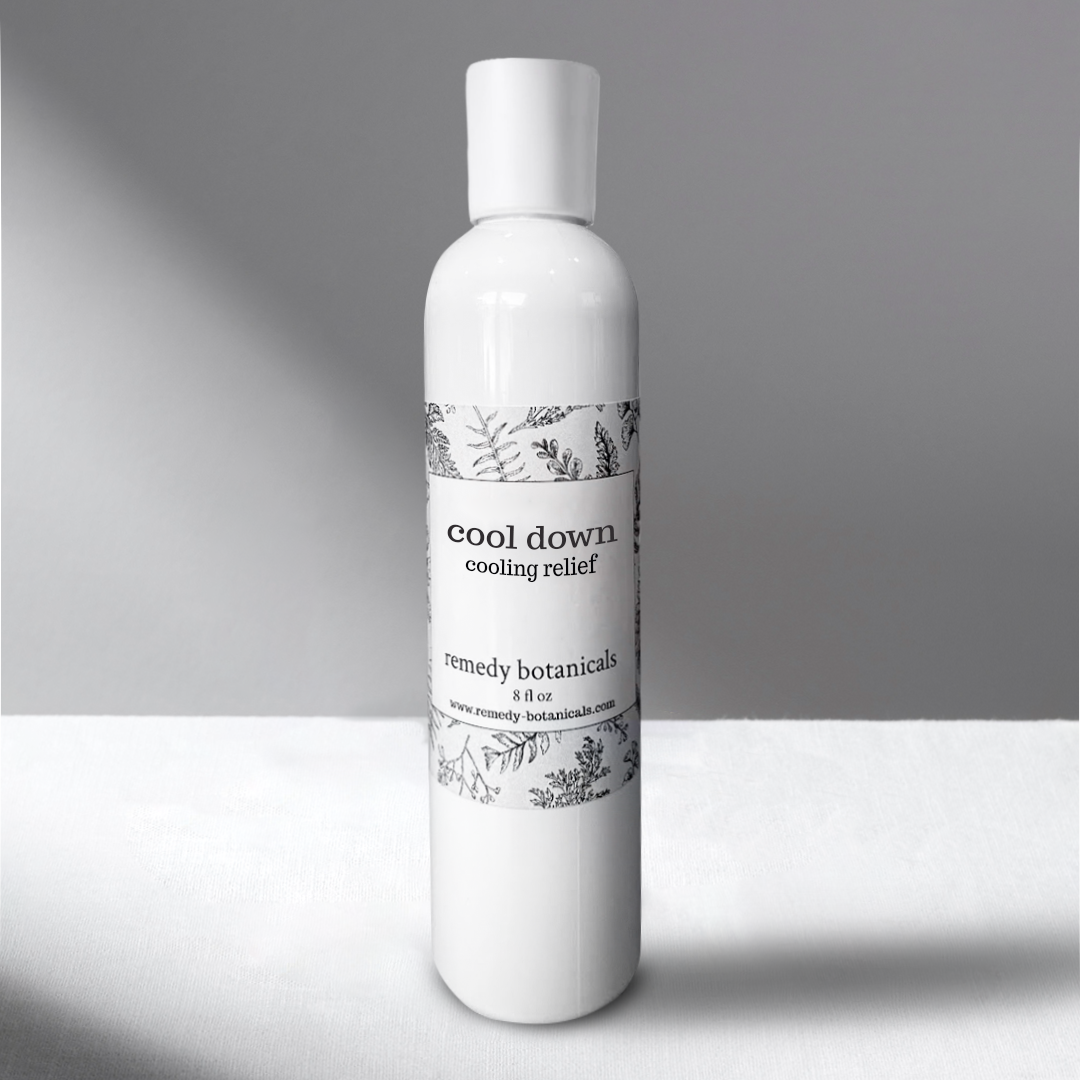 A 8oz white bottle of Cool Down Cooling Relief stands against a softly lit gray background.