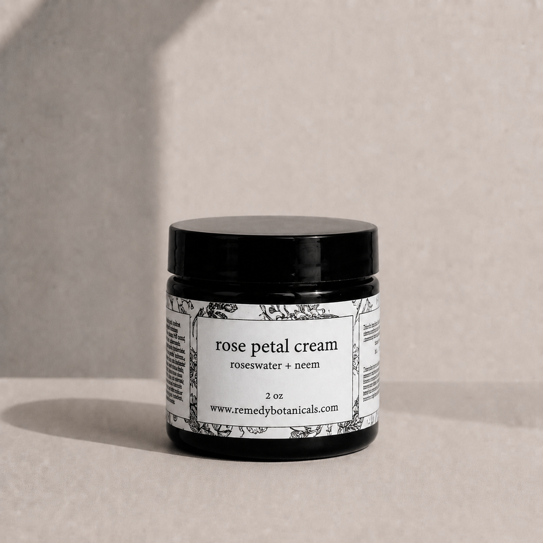 Jar of rose petal cream with a label on a neutral background