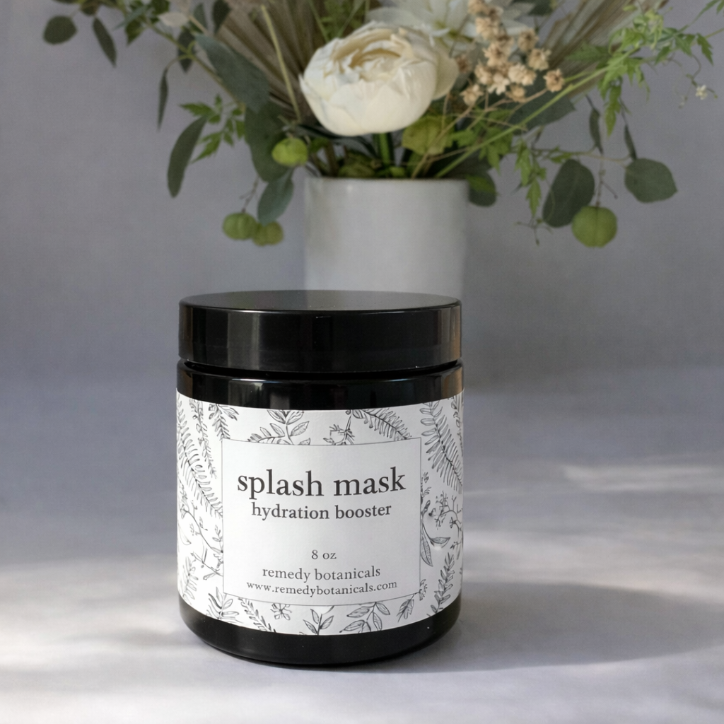 Jar of 'splash mask hydration booster' with a vase of flowers in the background