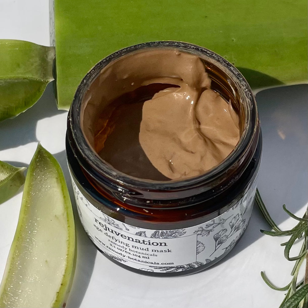 Open amber jar showing its rich brown texture, surrounded by fresh aloe vera slices.